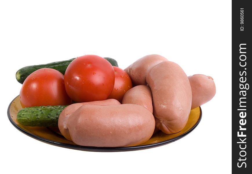 Small sausages with vegetables on a glass dish