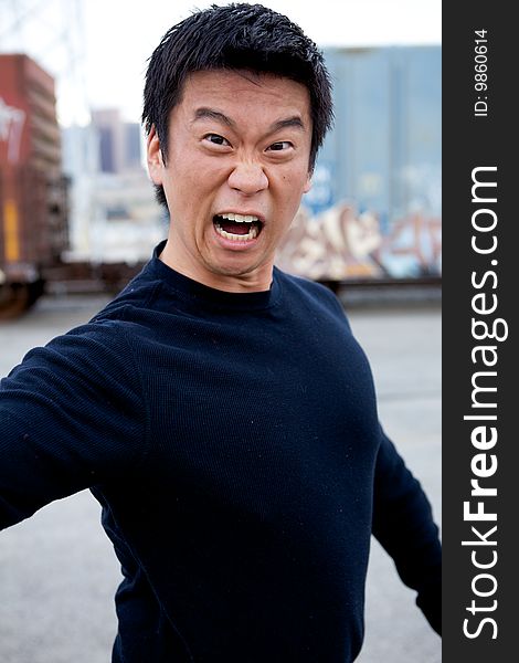 An angry asian man performing karate moves toward the camera. An angry asian man performing karate moves toward the camera