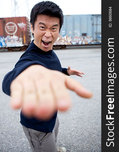 An angry asian man performing karate moves toward the camera. An angry asian man performing karate moves toward the camera