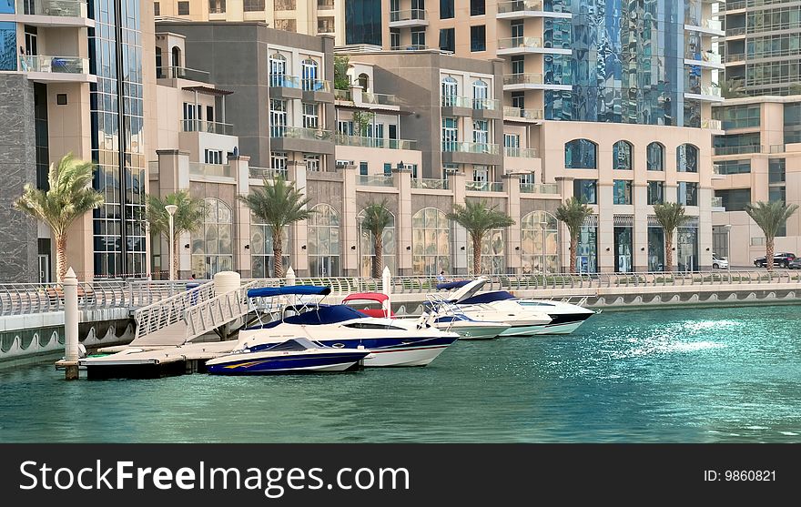 Dubai Luxury Apartments at the Marina with boats berthing infront of them.