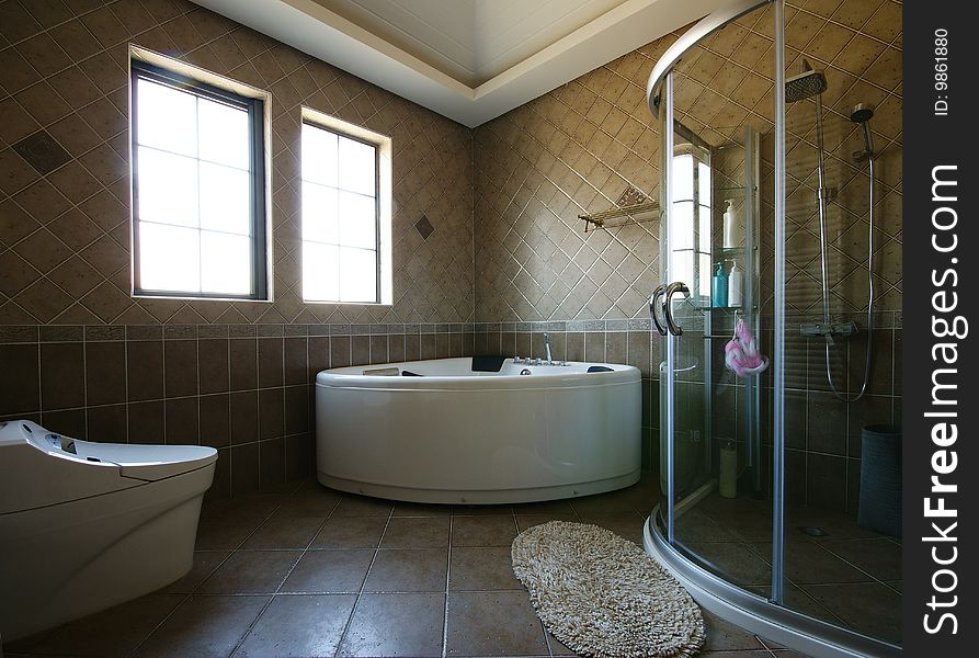 Bright and comfortable modern bathroom with curved tub and shower. Bright and comfortable modern bathroom with curved tub and shower.