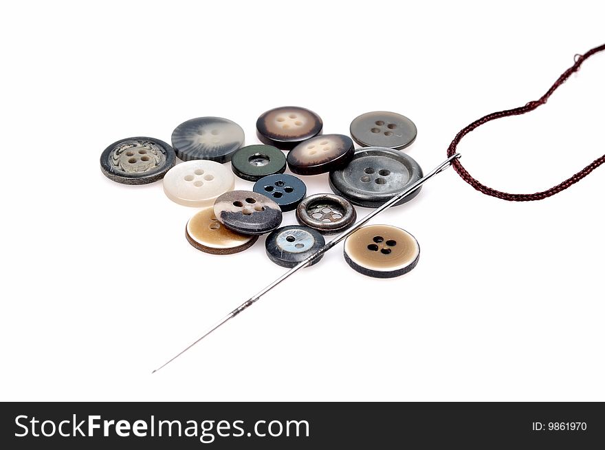 Buttons and needle isolated on white background.
