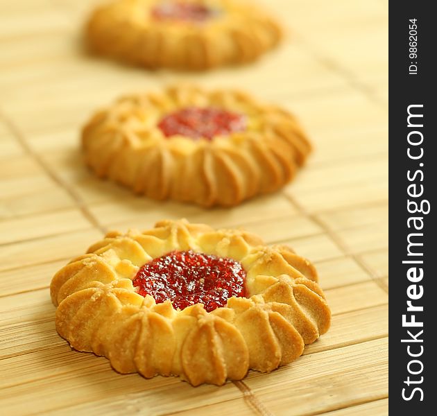 Tasty cookies with strawberry jelly, food background.