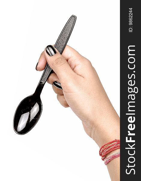 Female hand holding black spoon.