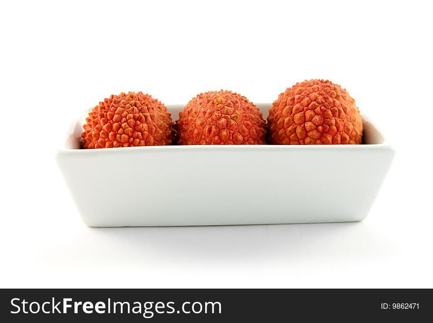 Three lychee in a dish with clipping on a white background