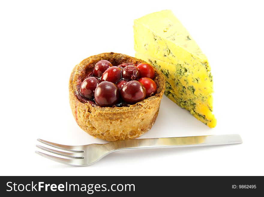 Pork pie and slice of blue cheese with fork and clipping path on a white background. Pork pie and slice of blue cheese with fork and clipping path on a white background