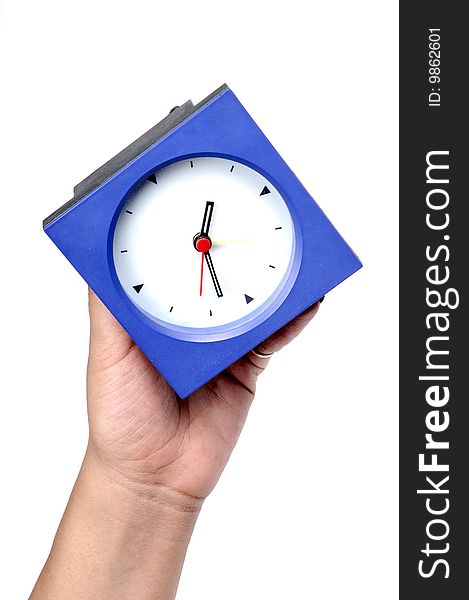 Feamle hand holding blue clock.