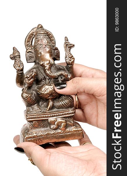 Female hand holding Ganesh statue.