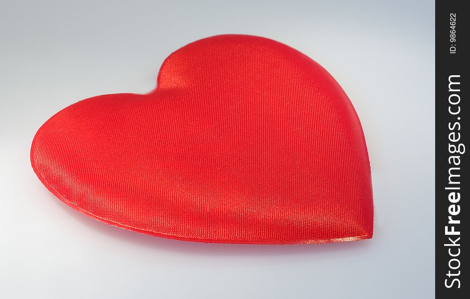 Heart from a red fabric on a grey background