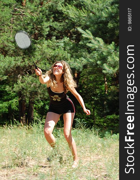 Beautiful young woman playing badminton outdoor. Beautiful young woman playing badminton outdoor