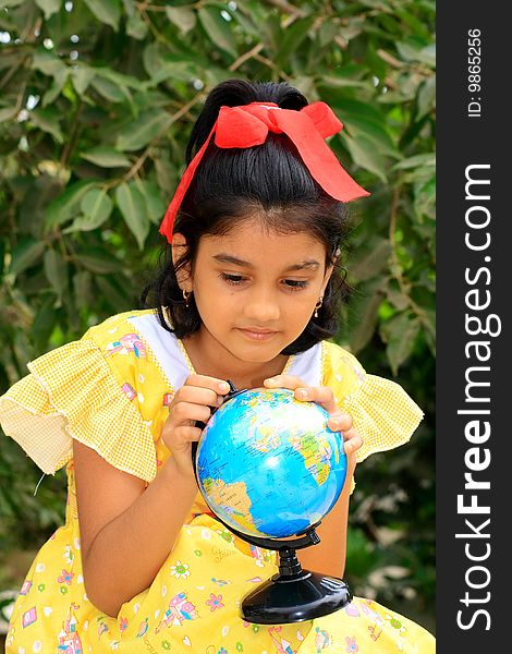 A bright Indian girl exploring and trying to find something on her educational globe. A bright Indian girl exploring and trying to find something on her educational globe.