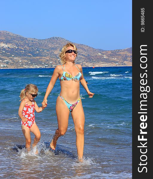 Mother and daughter running on beach. Mother and daughter running on beach