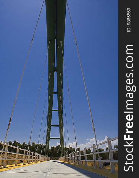 View of a suspension bridge. Blue sky at the background. View of a suspension bridge. Blue sky at the background.