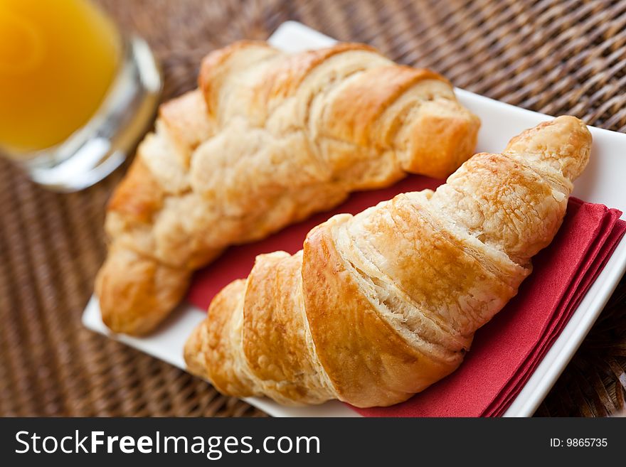 Continental breakfast with two croissants and a glass of orange juice