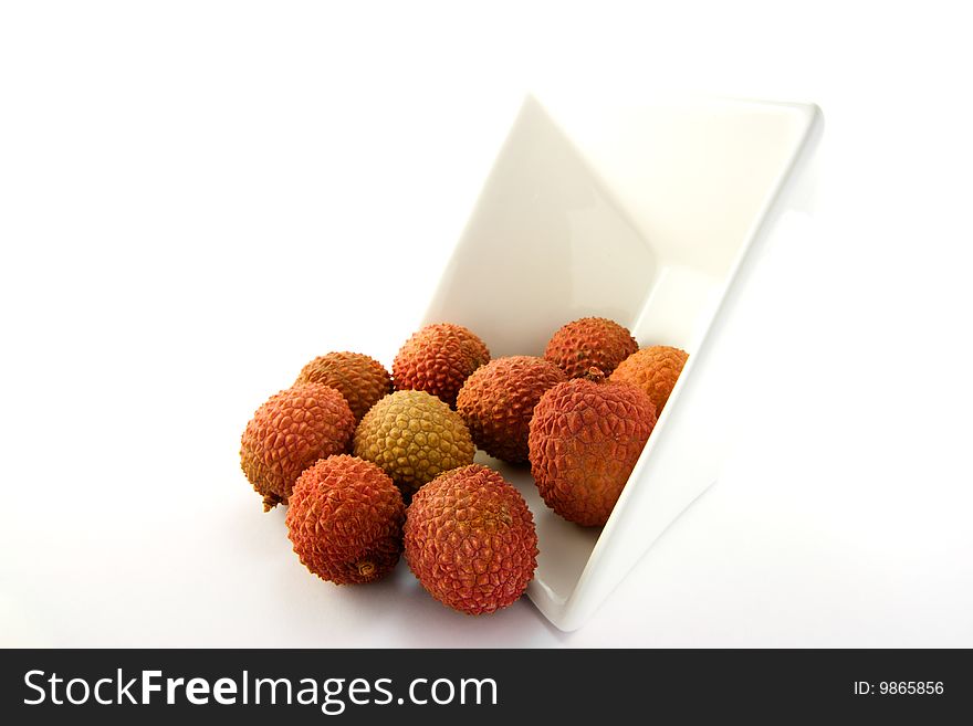 Lychee spilling out a dish with clipping on a white background. Lychee spilling out a dish with clipping on a white background