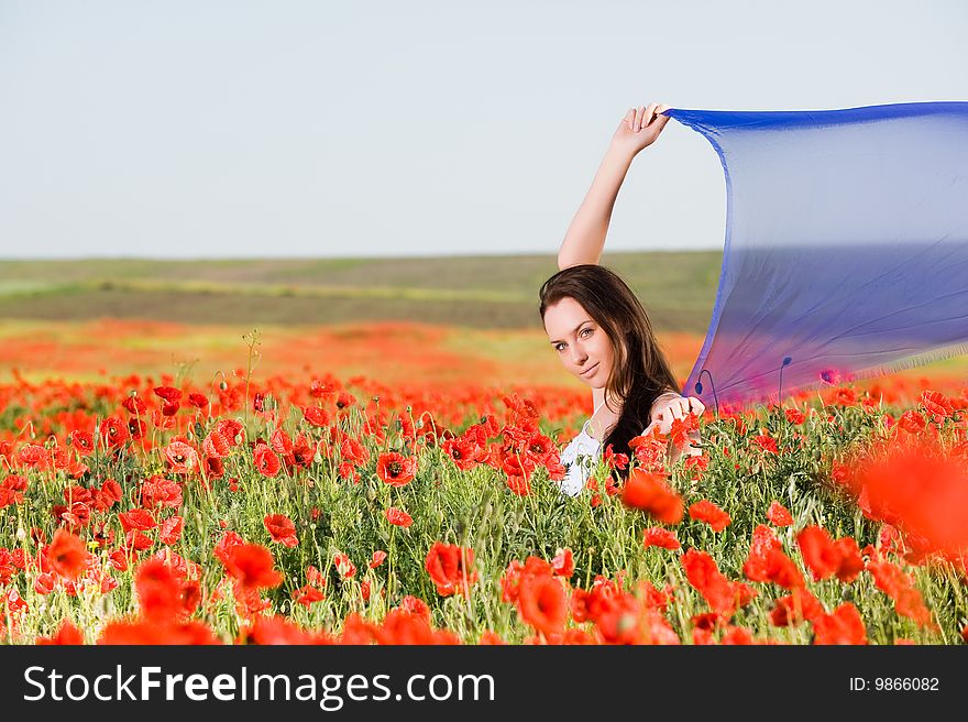 Attractive girl with blue scarf in the poppy field. Attractive girl with blue scarf in the poppy field