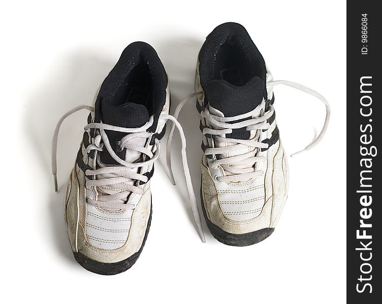 Old running shoes with shadows on a white background