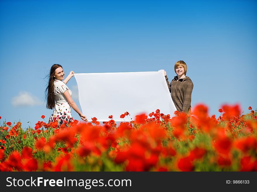 Lovely couple in the poppy field, copy-space for your text