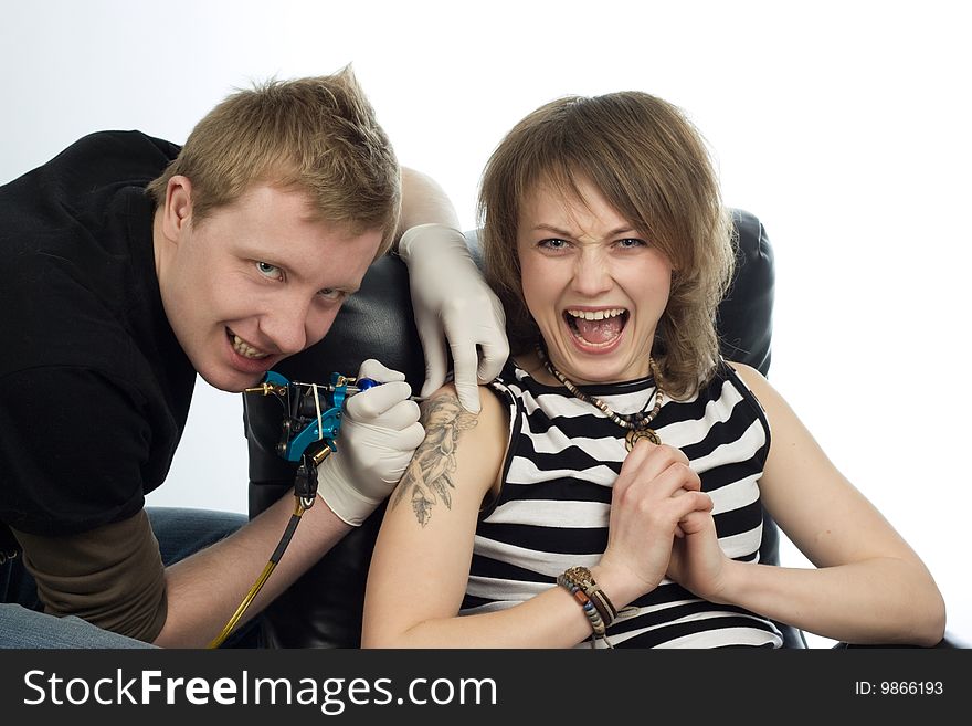 A man drawing tatoo pictures on woman's arm. A man drawing tatoo pictures on woman's arm