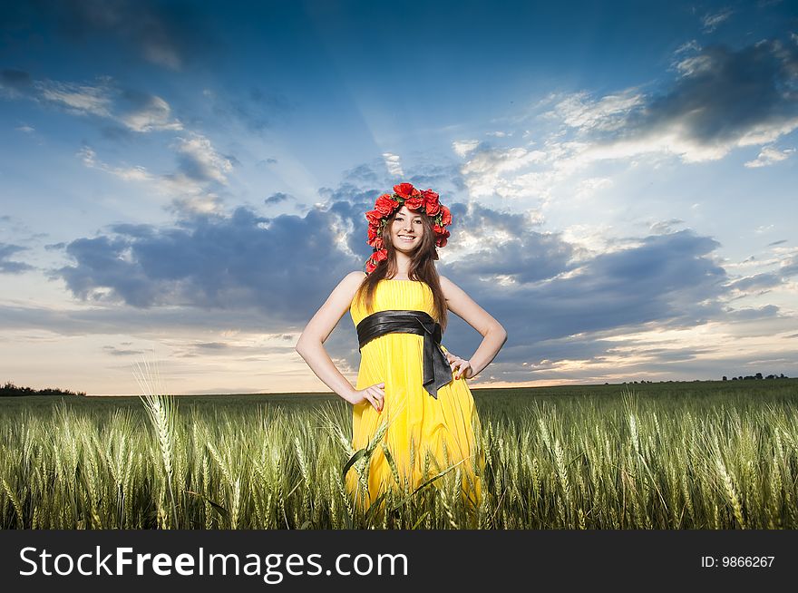 Beautiful young girl in floral wreath in the wheat field. Beautiful young girl in floral wreath in the wheat field