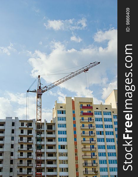 Tower crane on the construction site over blue sky