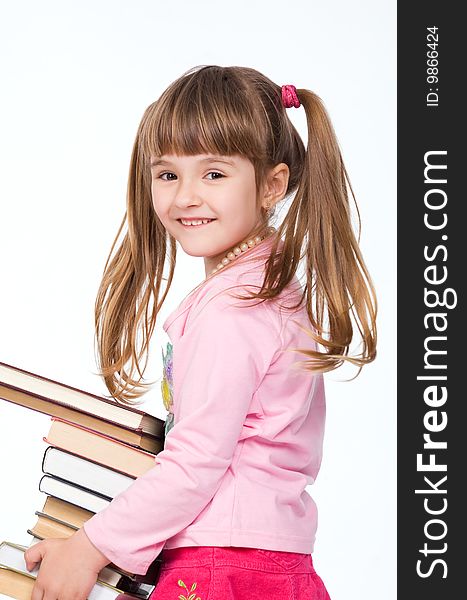 Pretty little girl holding stack of books