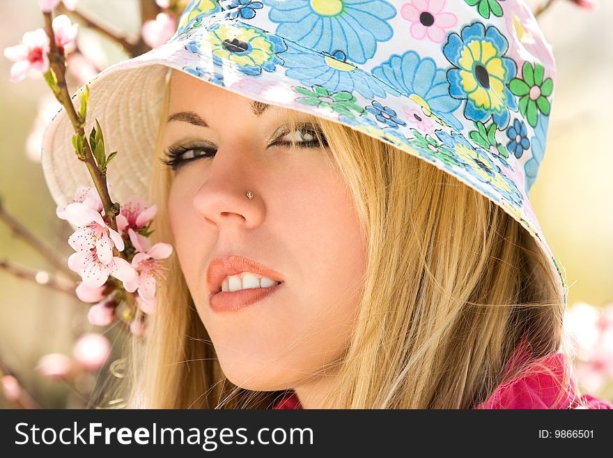 Closeup portrait of young woman over blossom trees. Closeup portrait of young woman over blossom trees