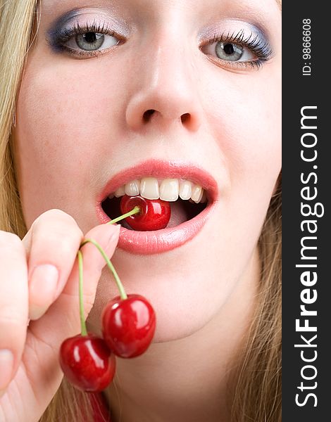 Healthy young woman eating red cherries