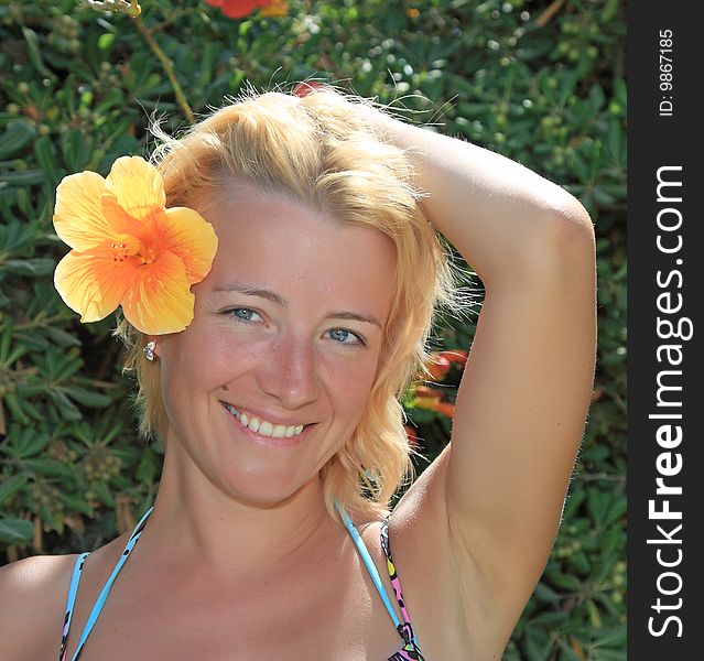 Portrait of the beautiful woman with a flower in hair