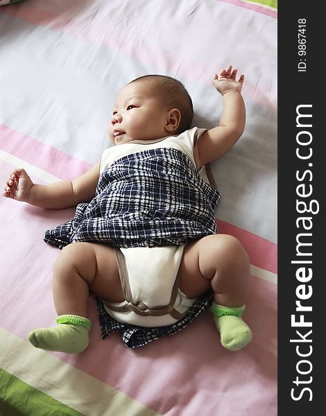 Newborn baby boy on bed.