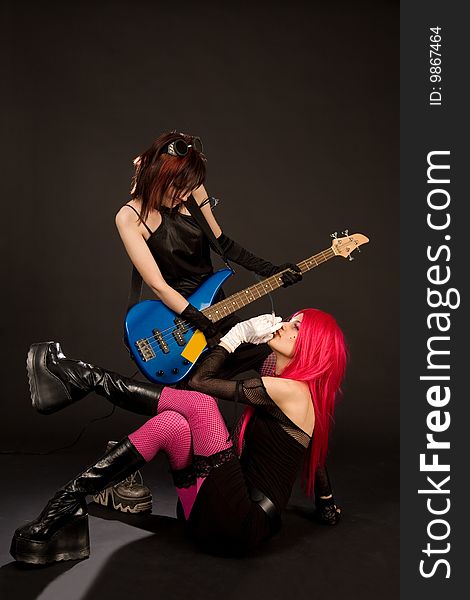 rock girls in crazy outfit with bass guitar and cigarette, studio shot. rock girls in crazy outfit with bass guitar and cigarette, studio shot
