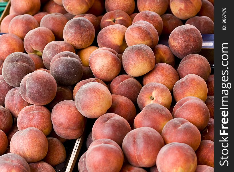 Fresh peaches in wooden crates at a market