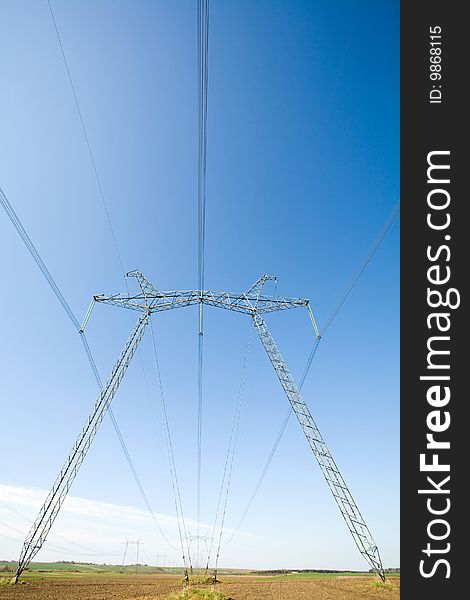 High voltage pylons on the background  of  blue  cloudless  sky