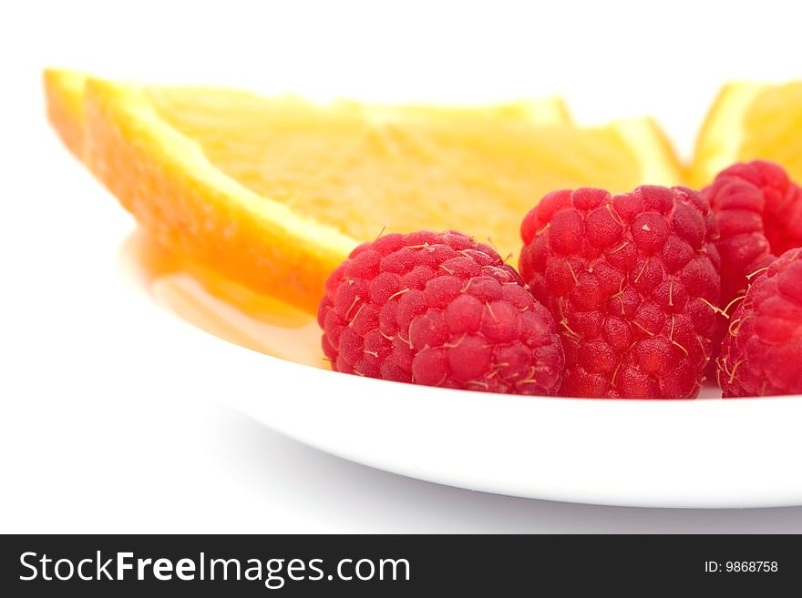 Raspberry and sliced  orange on plate. Raspberry and sliced  orange on plate