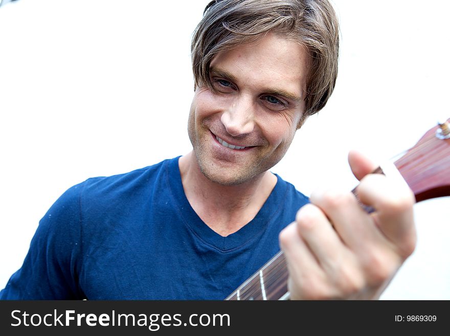 An attractive guitar player with a blue shirt and white background