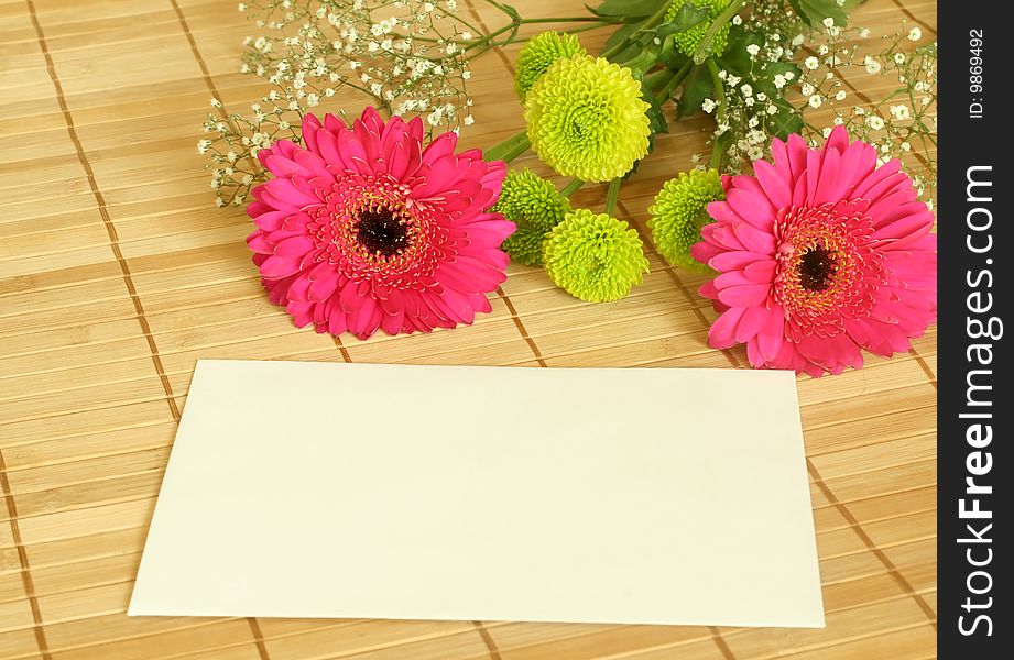 Spring bouquet with blank card on bomboo background