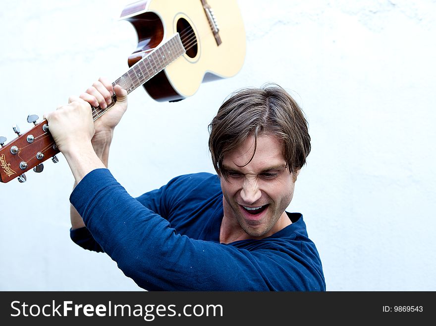An attractive guitar player with a blue shirt and white background