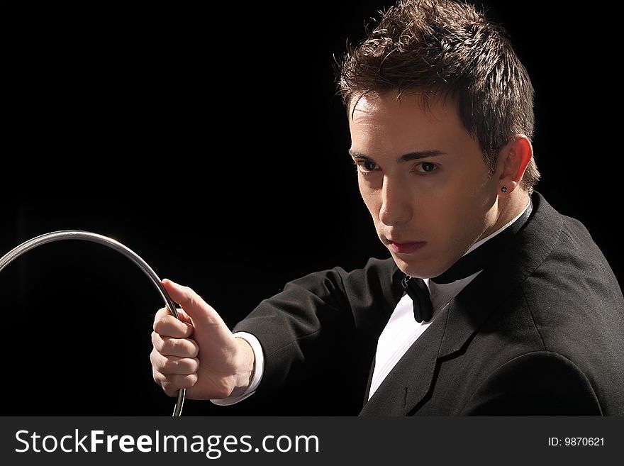 Young magician with silver metal rings on black background