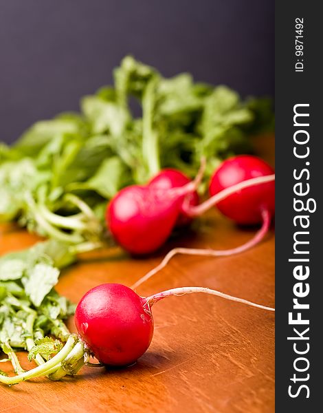 Radish on a wood cutting board leaves and roots