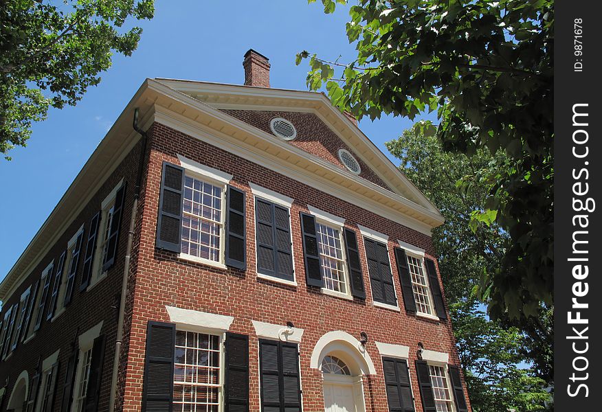 A 19th century classic American home in brick with wood shutters.