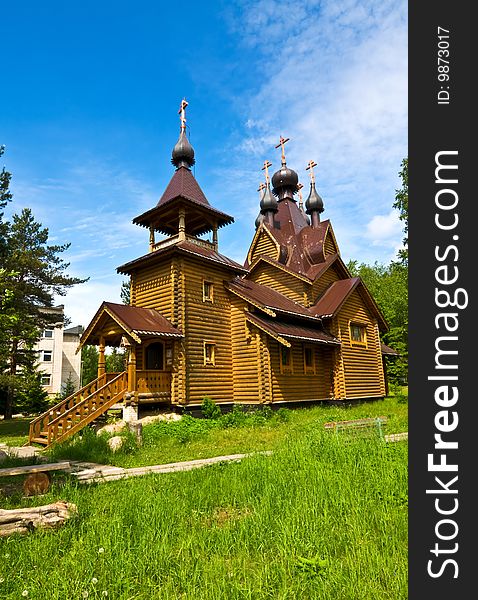 Beautiful wooden church with a porch on a background of blue sky