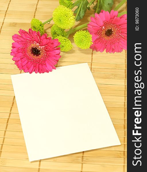 Spring bouquet with blank card on bamboo background