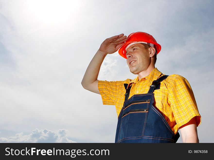 Engineer builder on a background of the blue sky