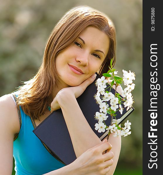 Pretty girl with a book and a flower outdoors. Pretty girl with a book and a flower outdoors