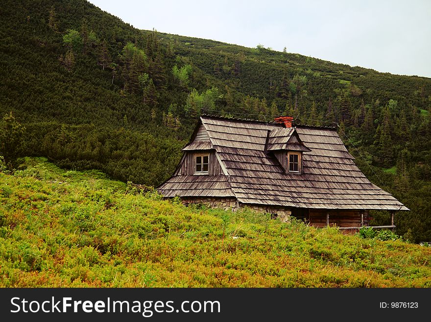 Wooden mountain hut with mountains in the background