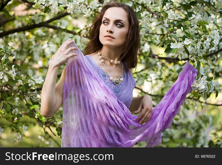 Tender girl in the garden with flowerings trees