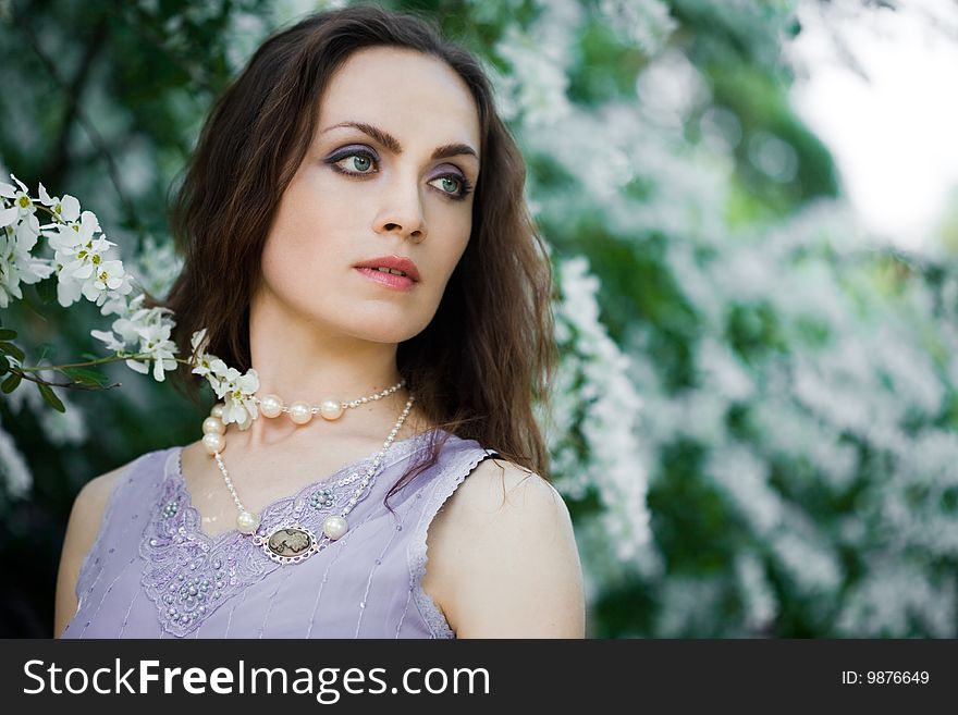 Tender girl in the garden with flowerings trees