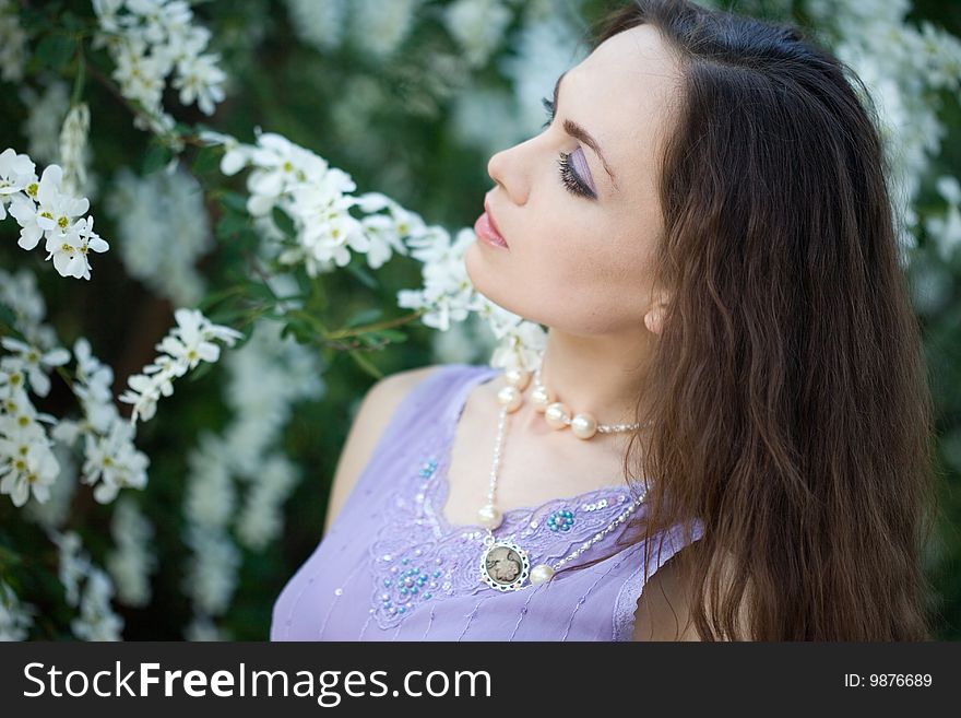 Tender girl in the garden with flowerings trees