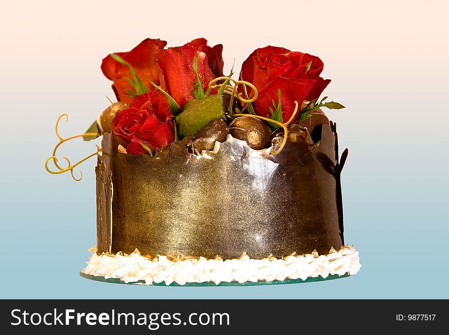 Closeup of a chocolate cake with red roses ontop.