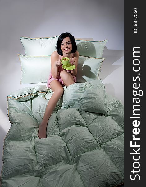 Young beautiful woman lying with down pillows and blanket. Young beautiful woman lying with down pillows and blanket